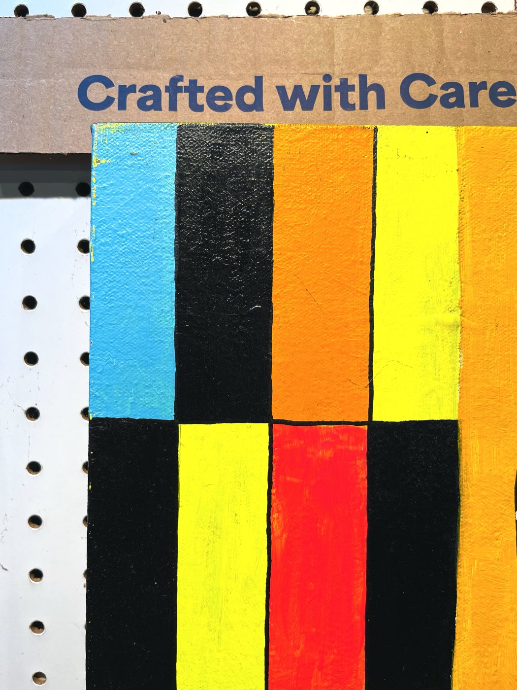 Detail of a striped painting mounted on pegboard